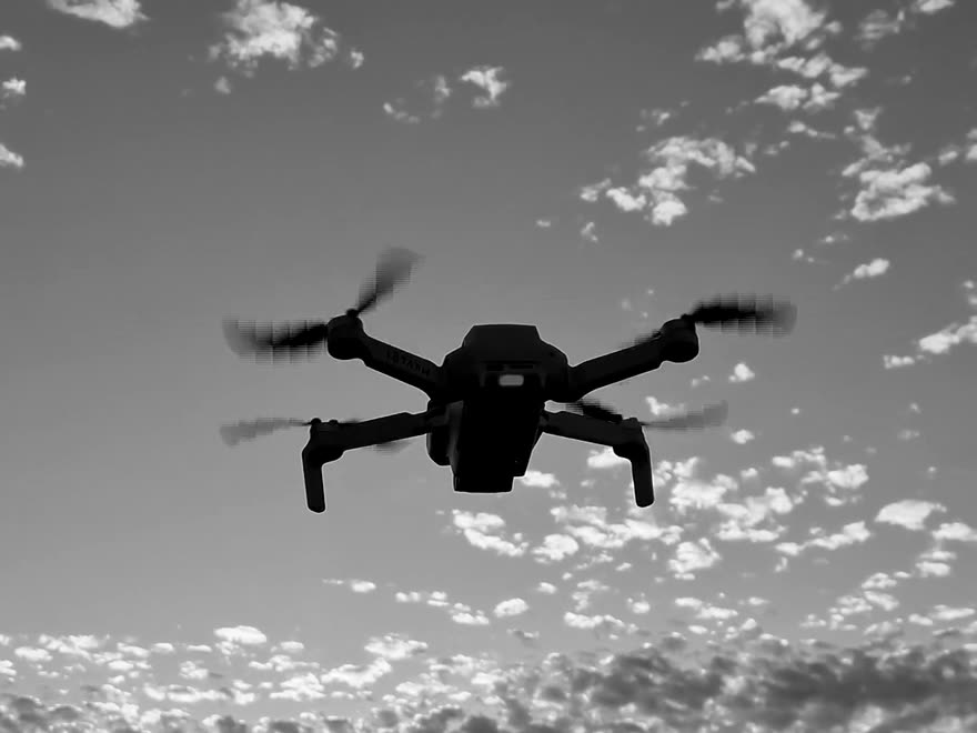 A drone in silhouette against the sky